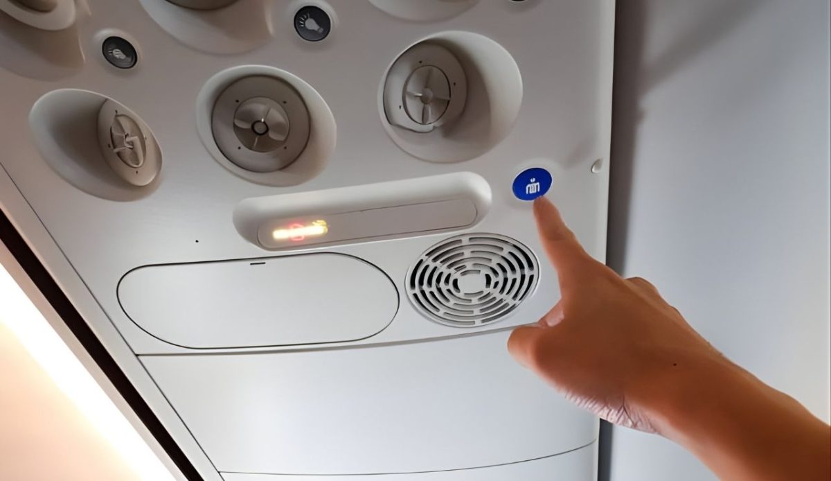 a person is trying to press button to call flight attendent                     