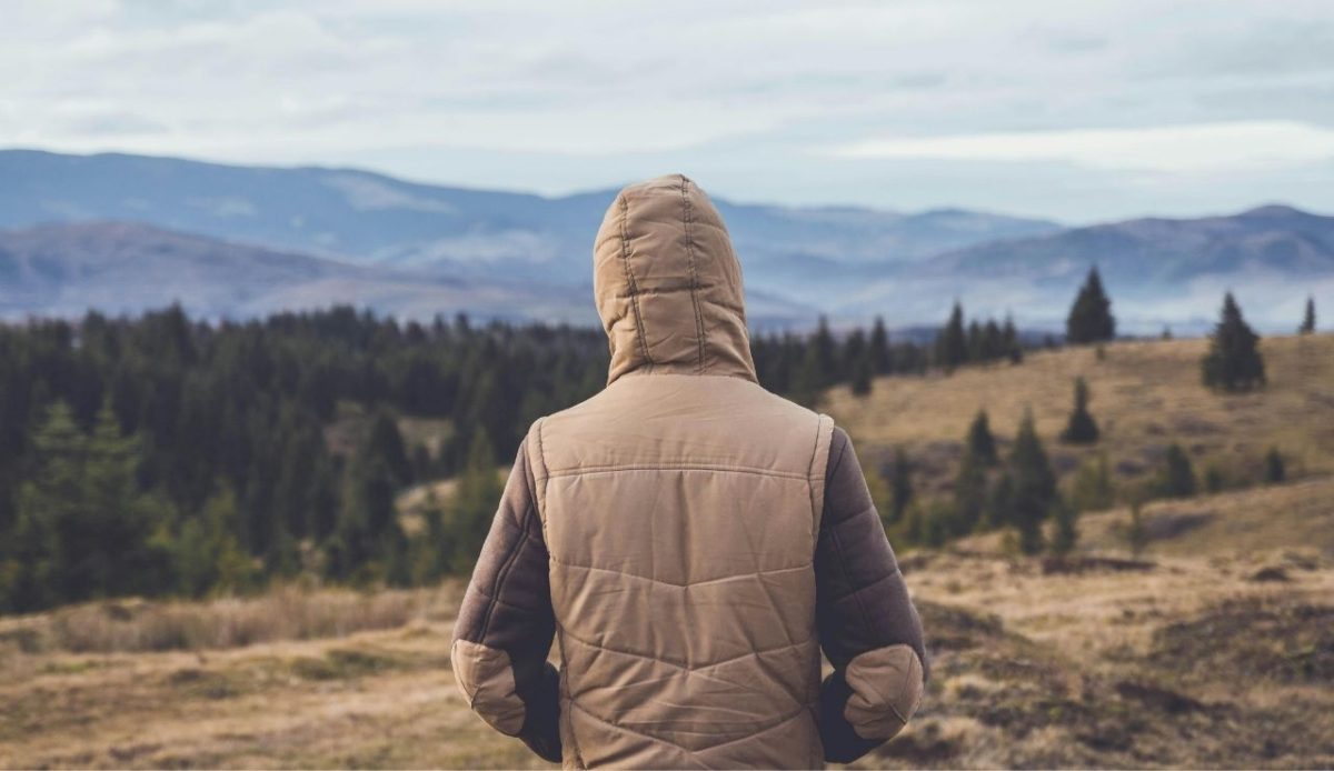 A visitor stays warm with layers in a chilly mountain setting, a reminder of Yellowstone’s fast weather changes                  