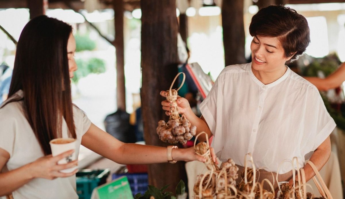 Ethnic women choosing ginseng at street market             