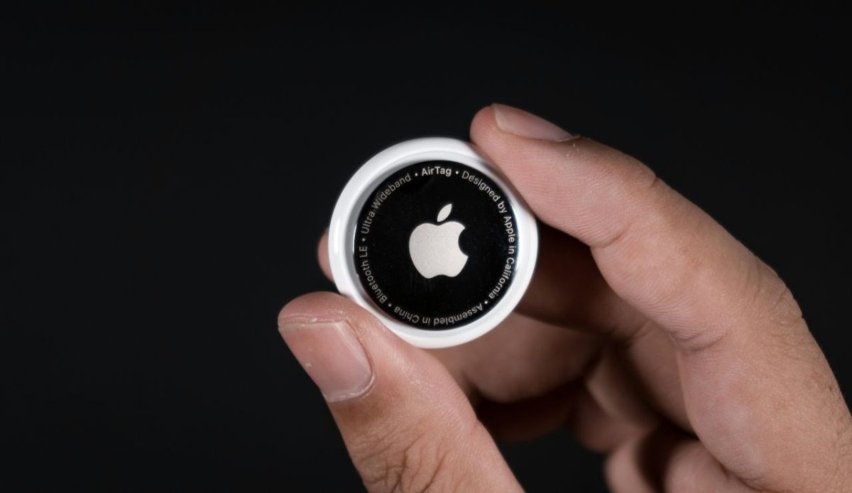 Hand holding an Apple AirTag tracking device                  