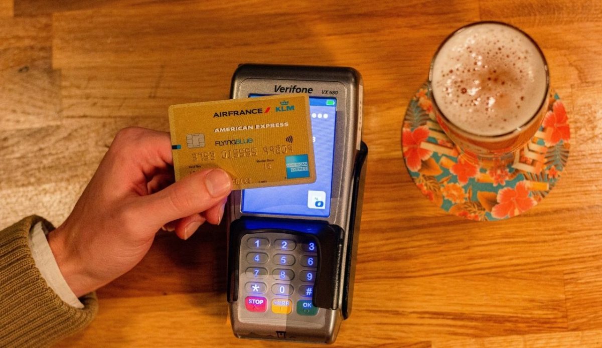 Hand holding credit card at payment terminal