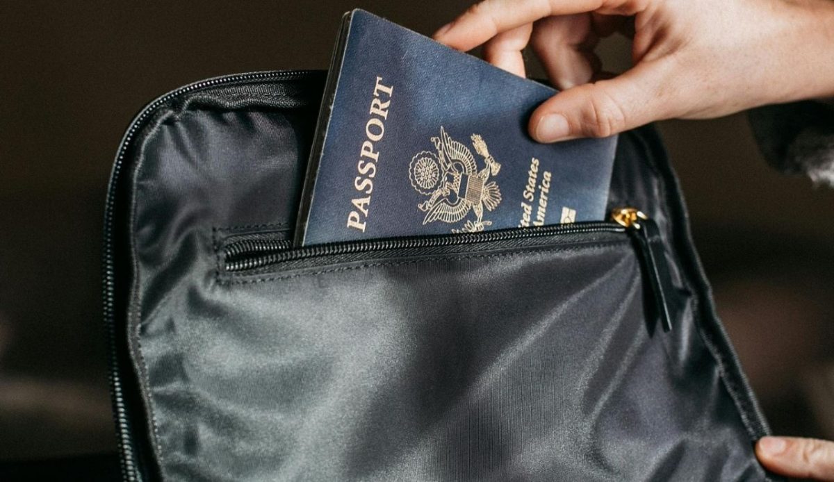 Person Putting a Passport in Bag                      