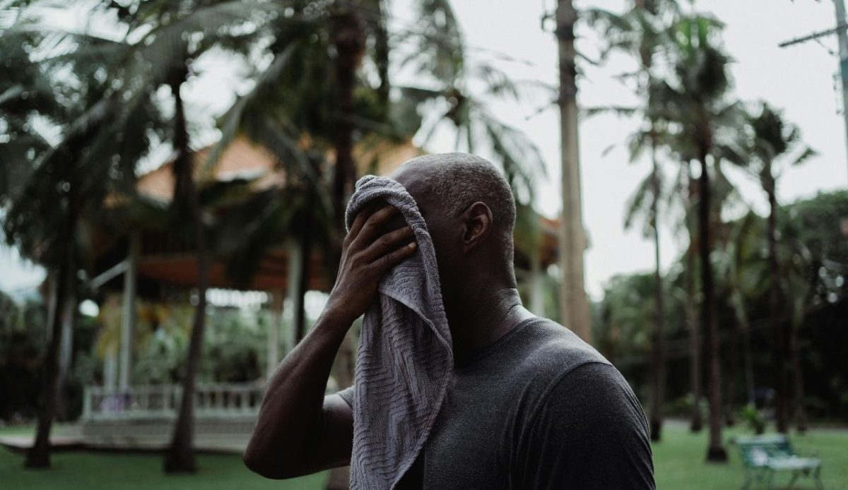 Man Wiping His Face with a Towel                     
