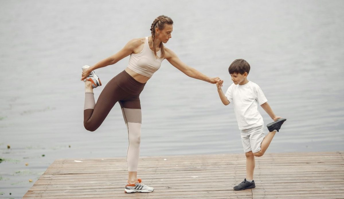 Mother and Son Practising Yoga on a Pier                     