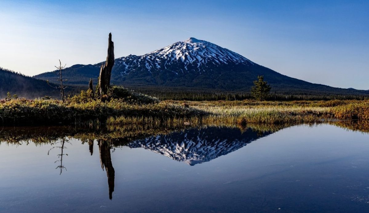 Snow capped Mount Bachelor reflecting in a calm lake, Bend Oregon USA           