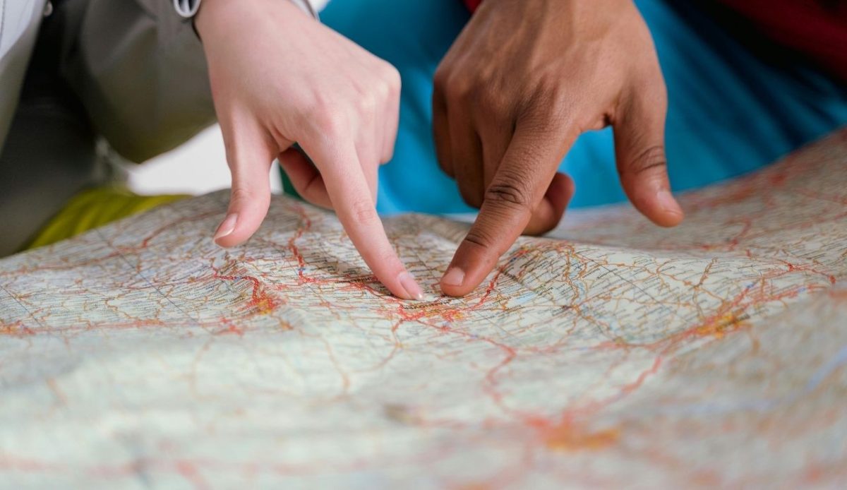 people pointing out location at map                   