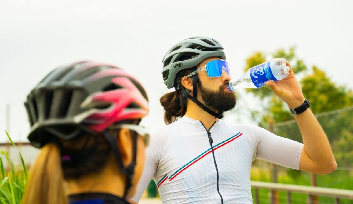 a cyclist is drinking water               