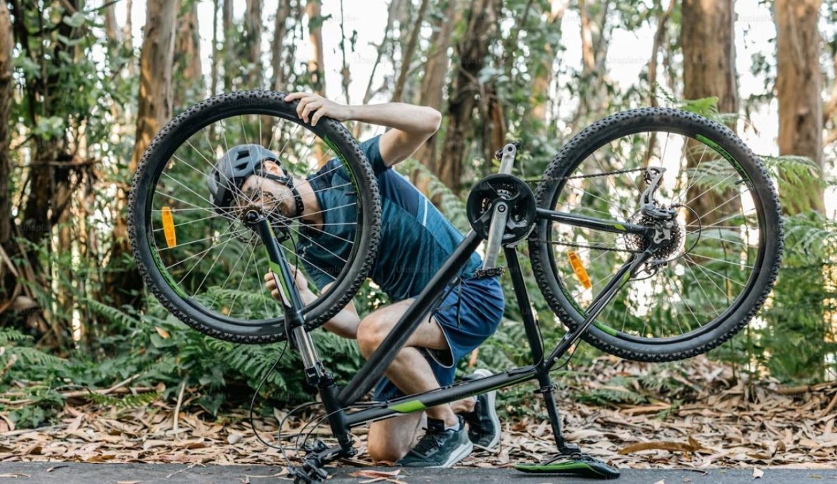 a cyclist is repairing his cycle                          