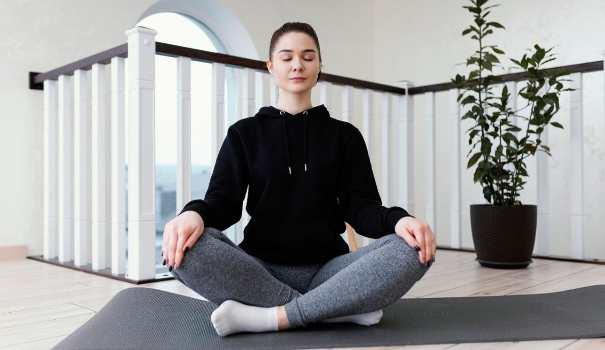 a female is sitting in a calm position doing exercise                  