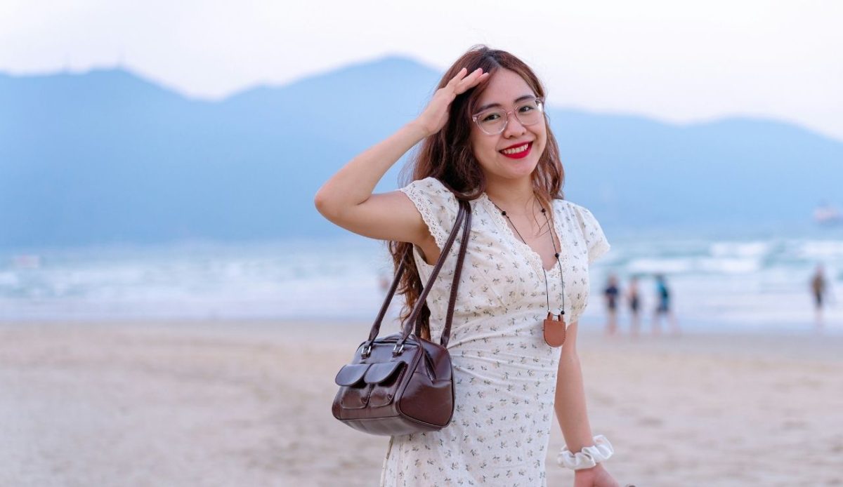 a girl standing on the beach with full dress              