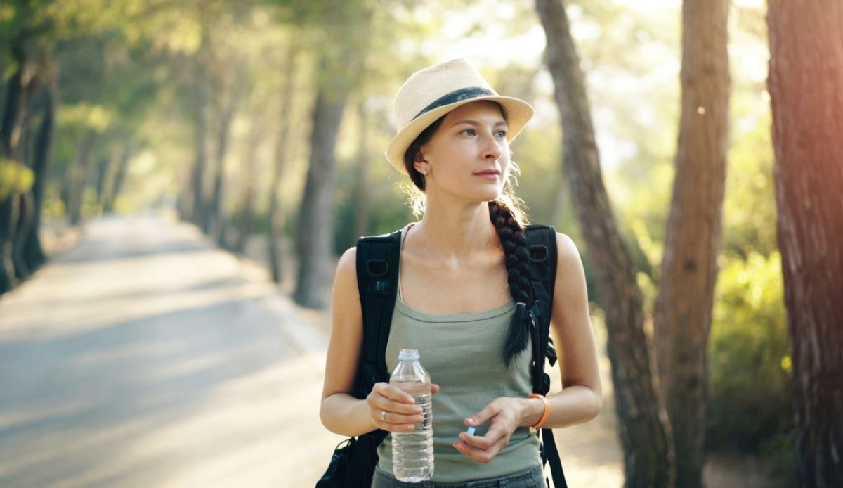 A woman in hat holding a water bottle