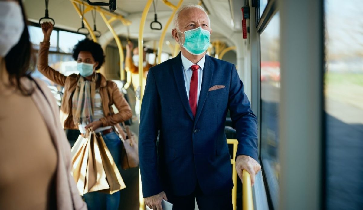 an old is wearing mask in public transport                      