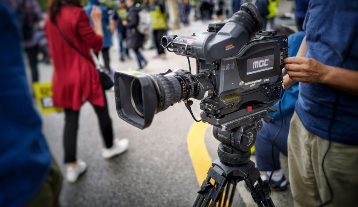camera-man operating black camera           
