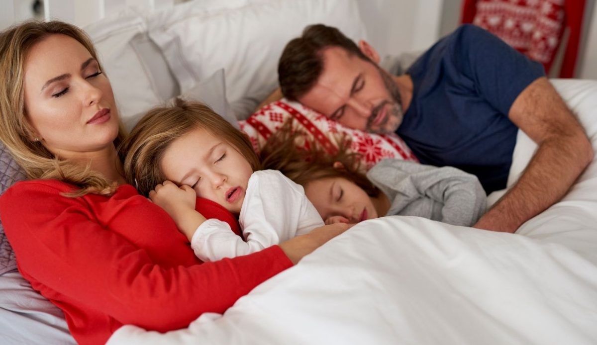 family sleeping in bed                      