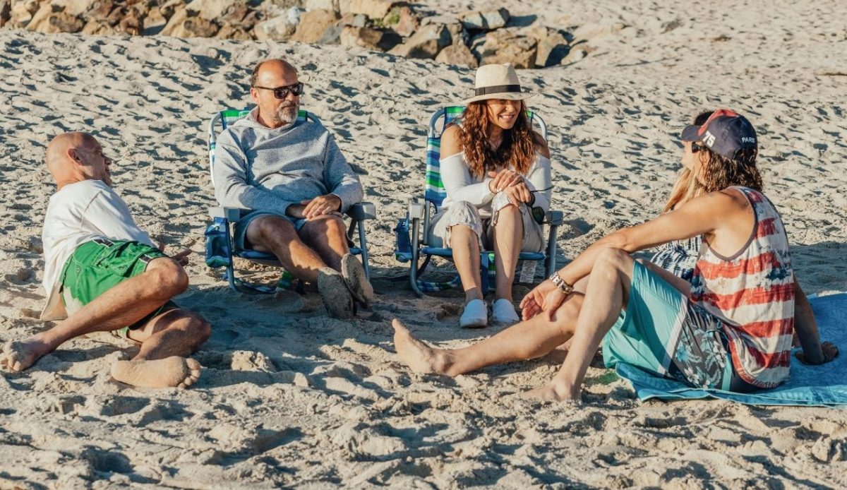 old people are talking with each other at beach                              