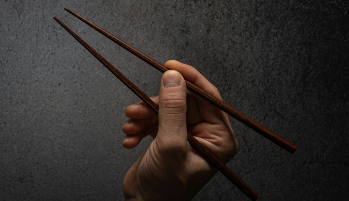 a person holding Chopsticks in his hand                                  