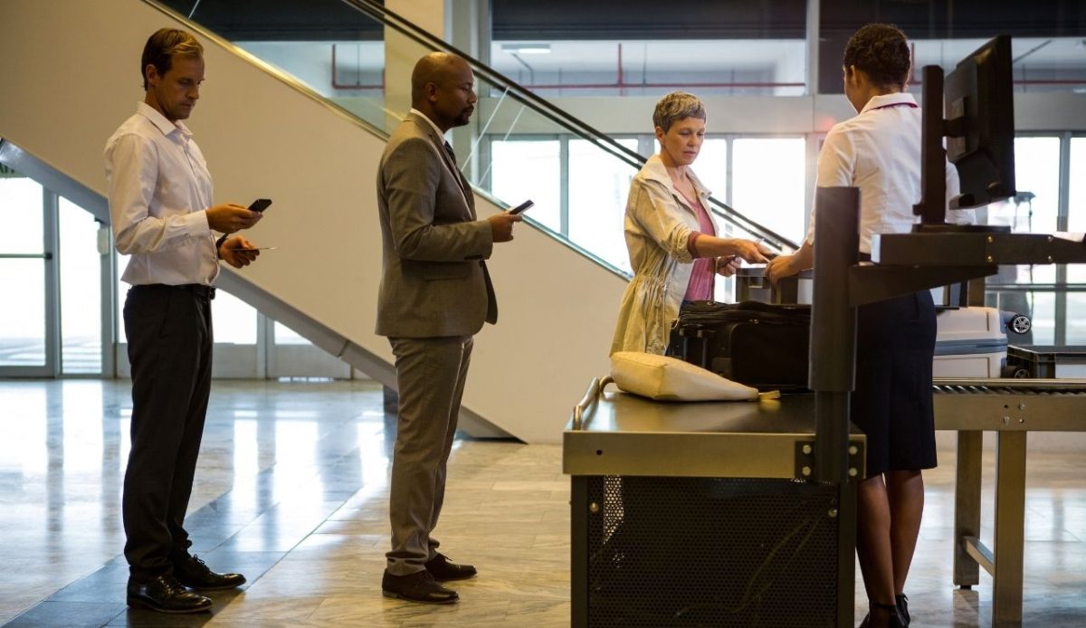 Airline check-in attendant handing boarding pass to passenger                