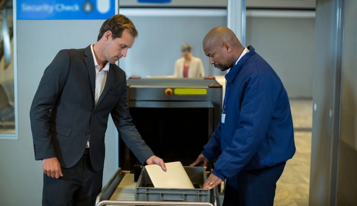 Airport security officer checking package of passenger                            