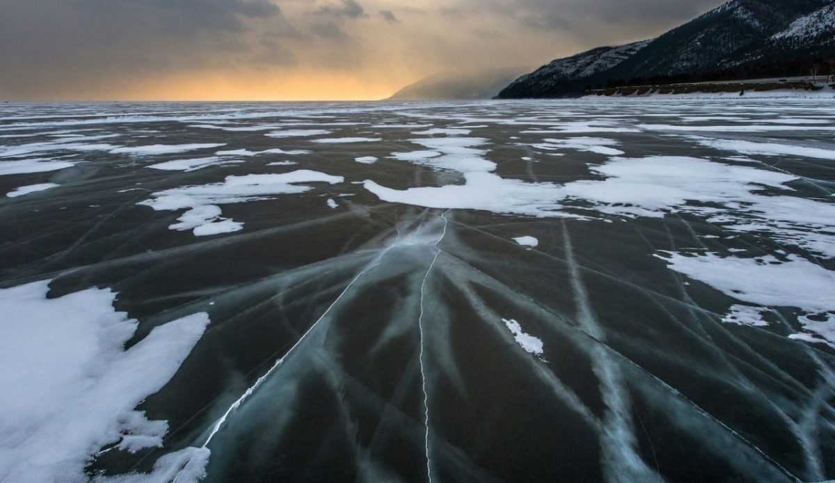 Frozen Lake Baikal ice with mountain cliffs, Siberia, Russia                               