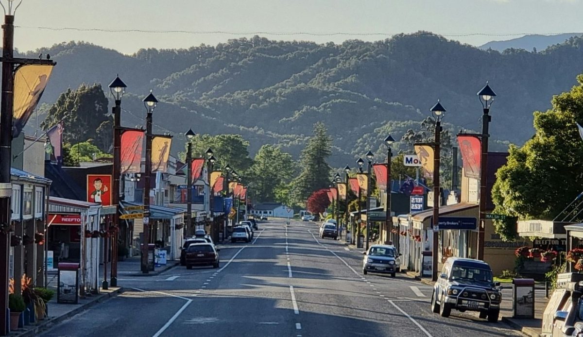 11 Countries That Are Perfect for Epic Cultural Road Trips 10 Main street of Reefton New Zealand with cars and mountains in the background