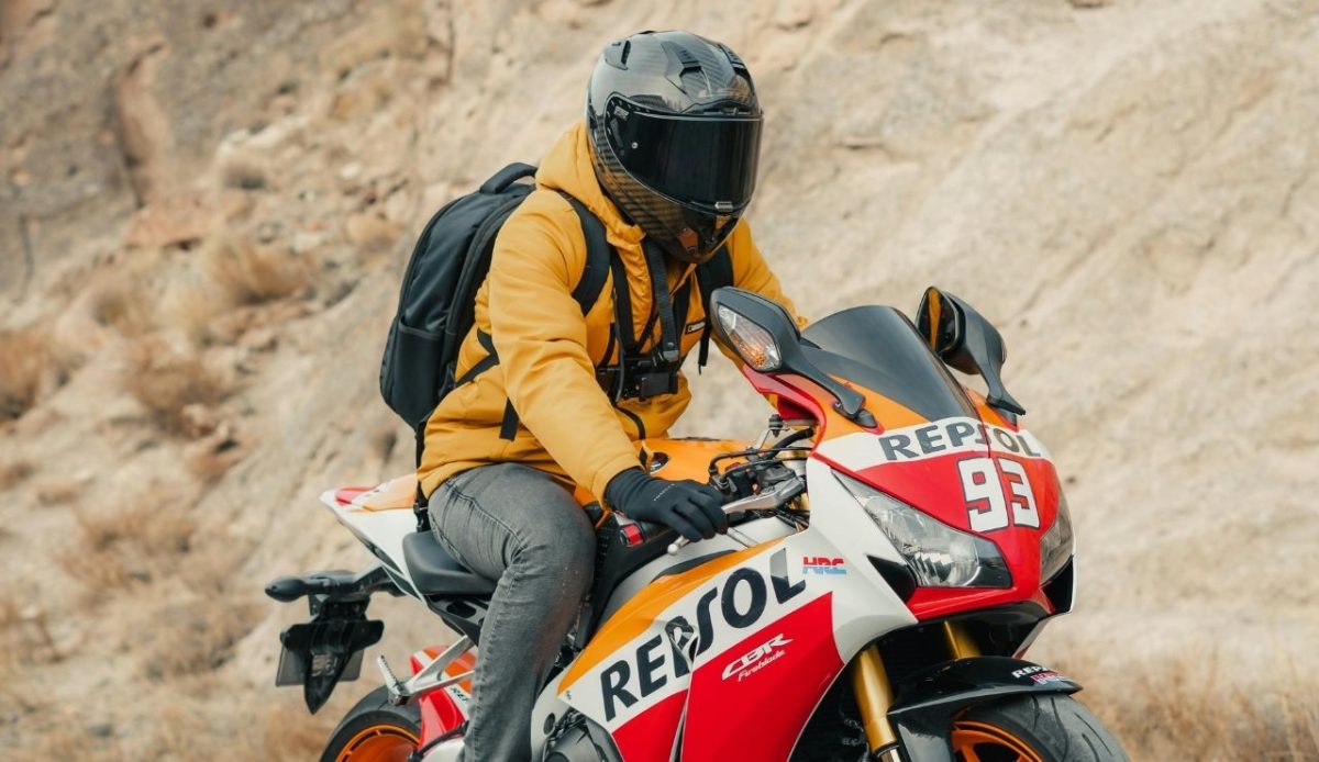 Man in Helmet Riding Motorbike in Desert                                           