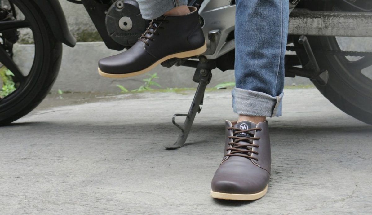 a man wearing jeans and new shoes sitting on bike                                 