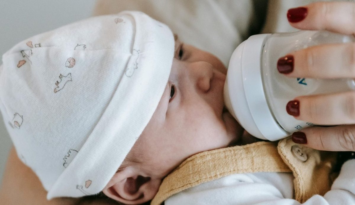 feeding baby with milk feeder                      