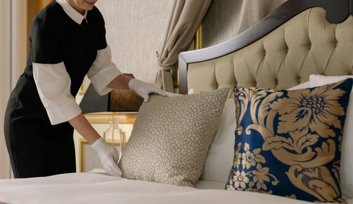 hotel waitress arranging the Bed with pillow     