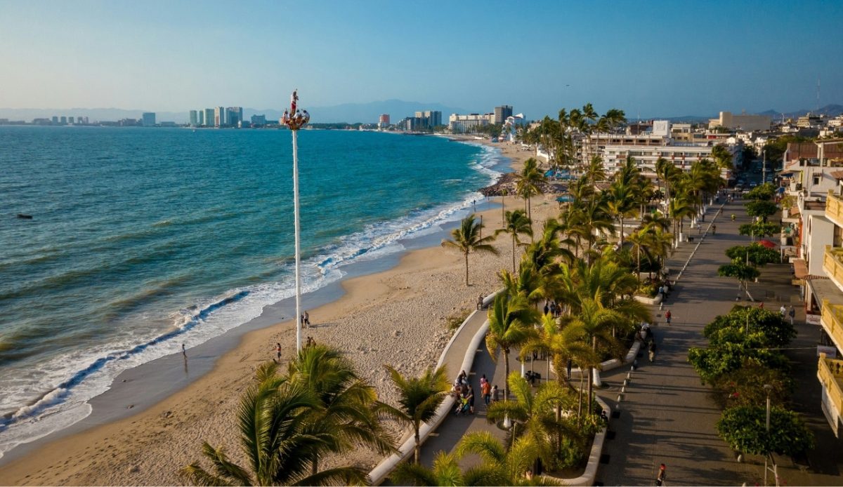 View of the beach and promenade in Puerto Vallarta, Jalisco, with palm trees and the ocean 