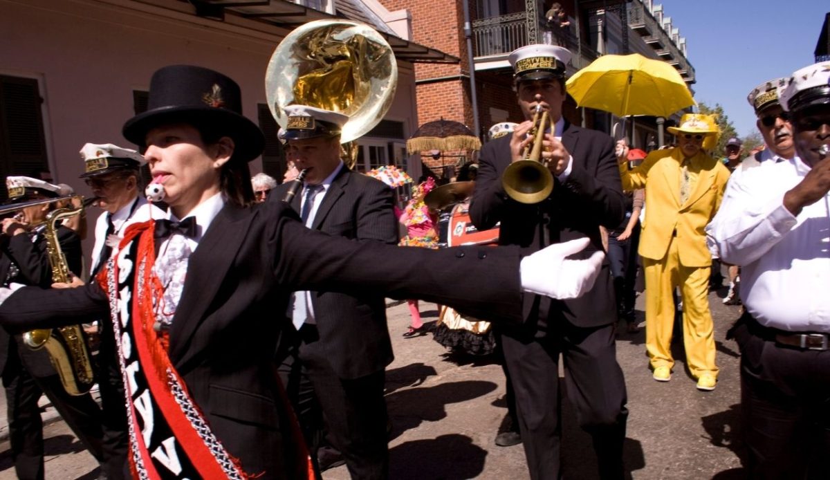 Local jazz singer Jane Harvey Brown leads the way as grand marshal for a brass band at a second line in the French Quarter in New Orleans.                   