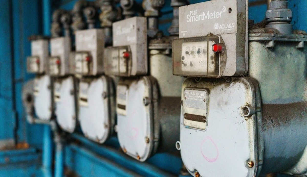Row of industrial utility meters on blue wall                         