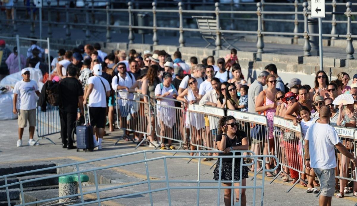 Tourists waiting in a long ferry line at the port      