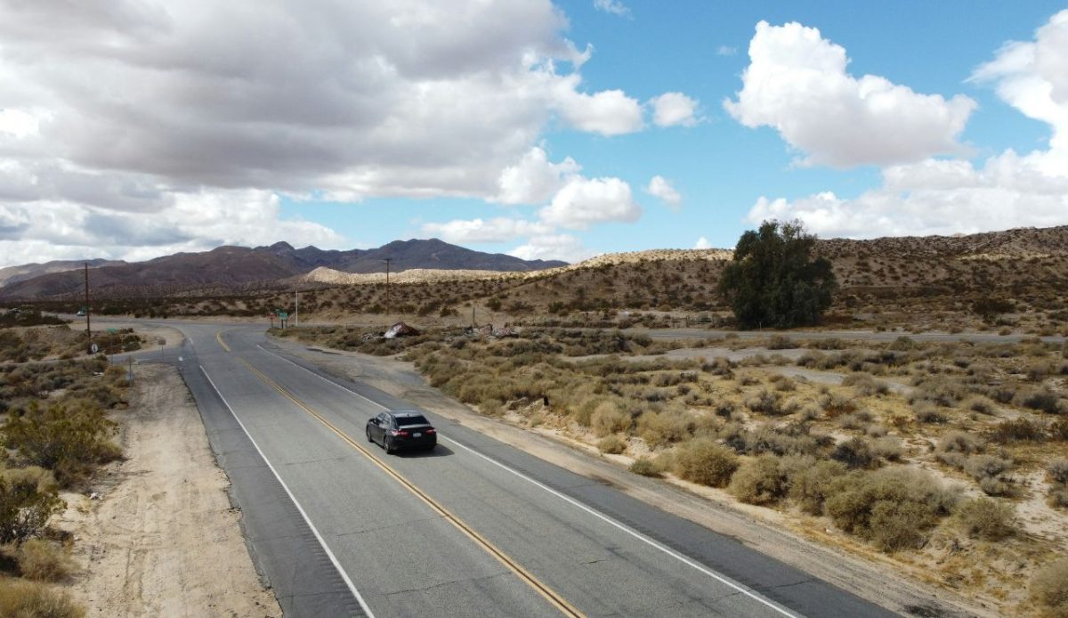 Distant car driving on a lonely desert highway