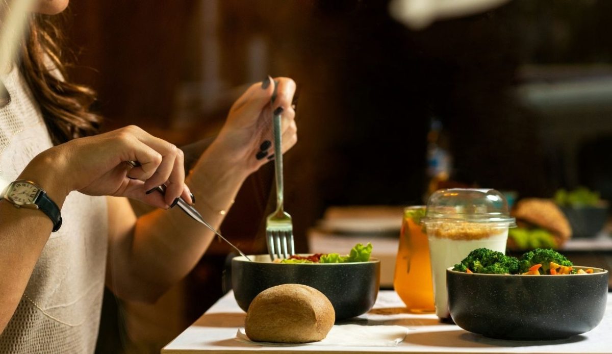 Women eating tasty chicken salad with dessert                                     
