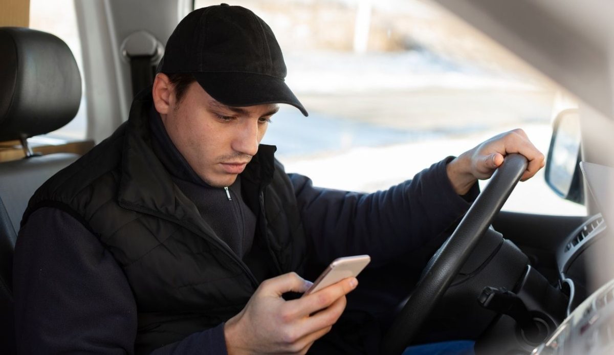 a car driver is looking on mobile                           