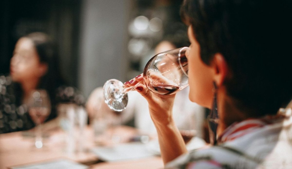 a woman is drinking wine at table                     