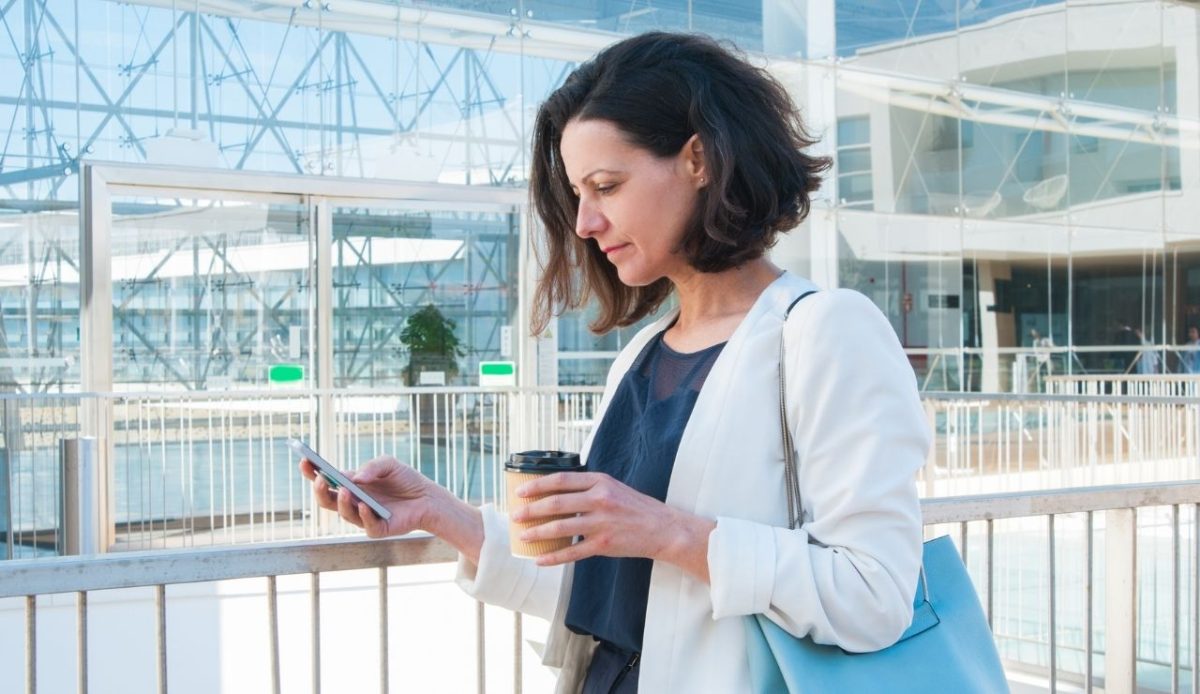 businesswoman texting with handbag at airport                           