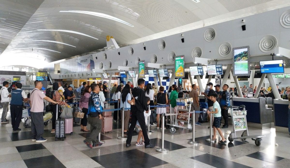 corwd of people at airport waiting at booking counter                             