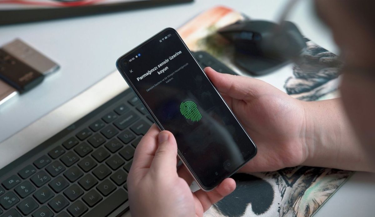 man holding phone with biometric authentication on screen                       