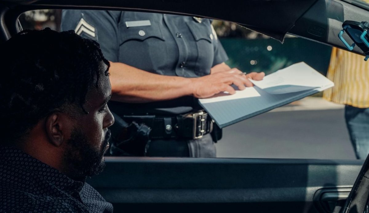 police officer standing next to car investigating car driver            