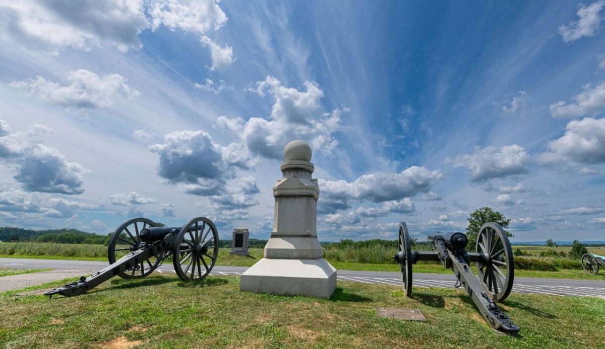 12 Heritage Towns in America Locals Say Are Turning Into Theme Parks 10 Gettysburg, Pennsylvania, United States Gettysburg Battlefield Cannons under a Dramatic Sky