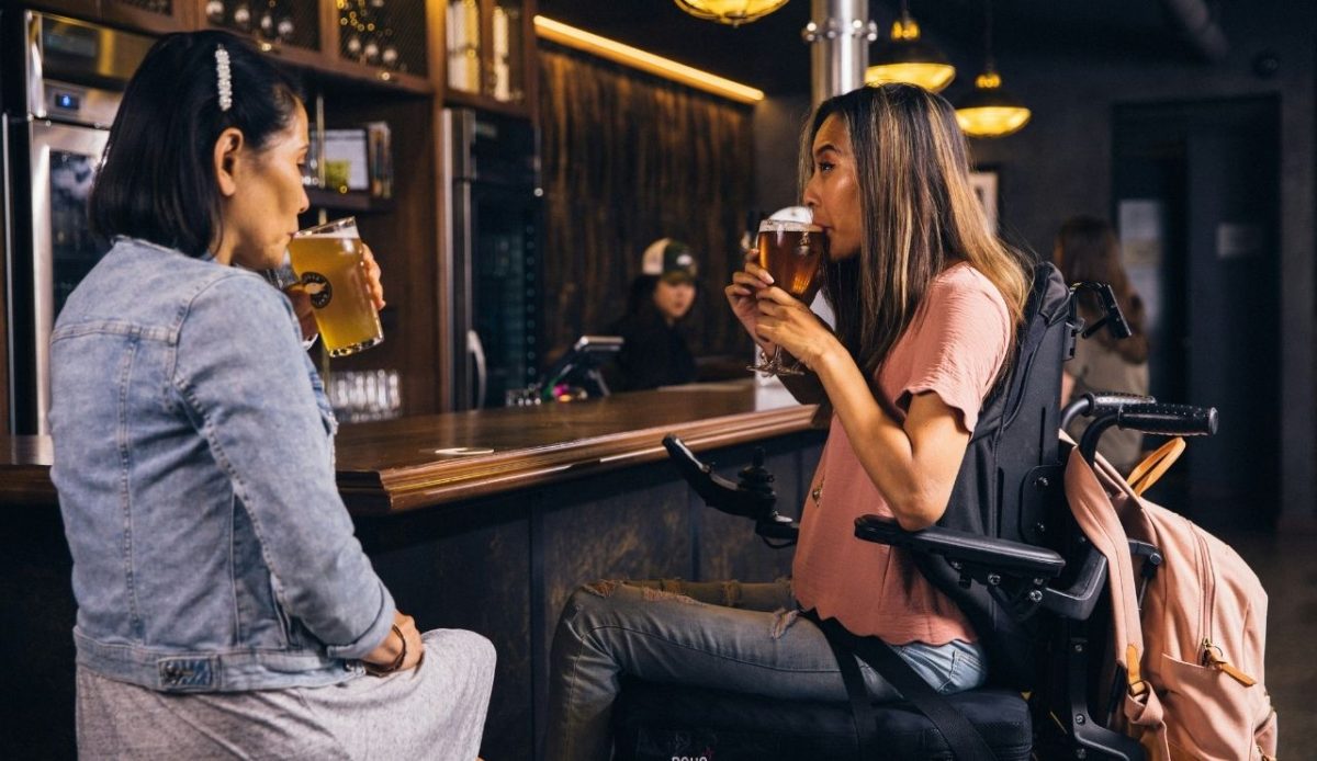 two friends are drinking beer inside bar                     