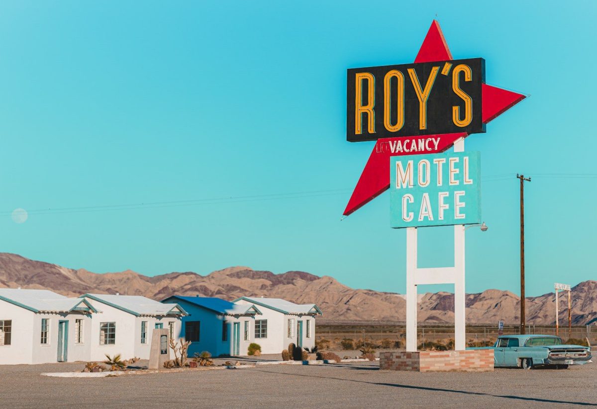 A motel sign with a car parked in front of it
