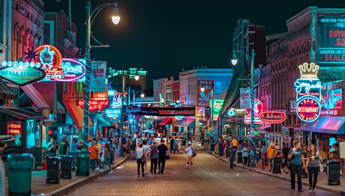 8 Beautiful Streets Around the World to Walk at Least Once 7 people walking in middle of road in between establishments at night time