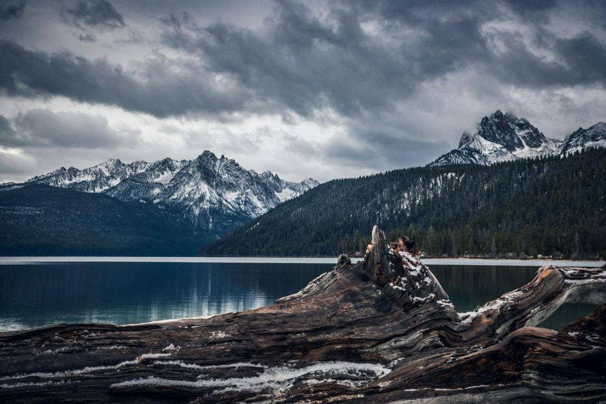 Majestic view of snow-covered mountains and pristine lake in Idaho's wilderness.