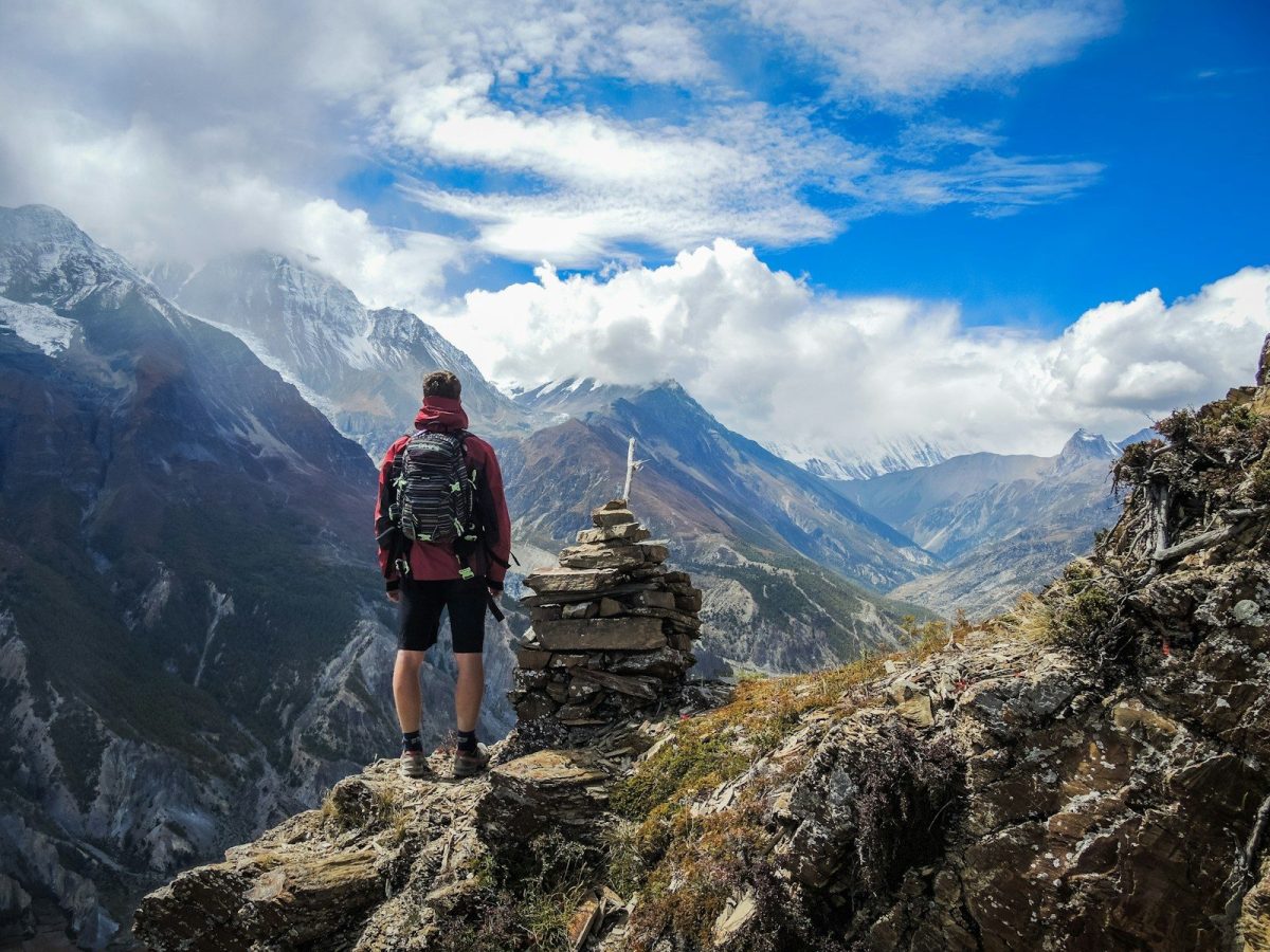 9 Essential Safety Tips for Solo Travelers 1 man standing on top of mountain beside cairn stones