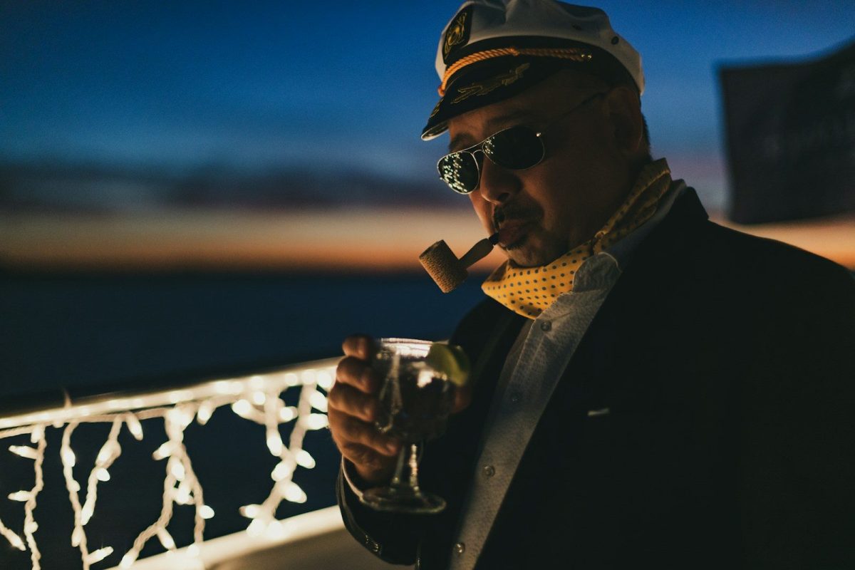 A man smoking a cigar and drinking a glass of wine