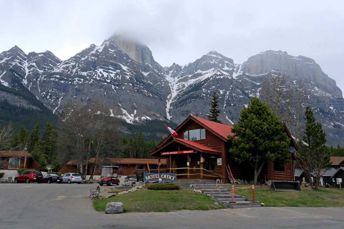 Mountain lodge with snowy peaks in the background, offering a rustic getaway vibe.