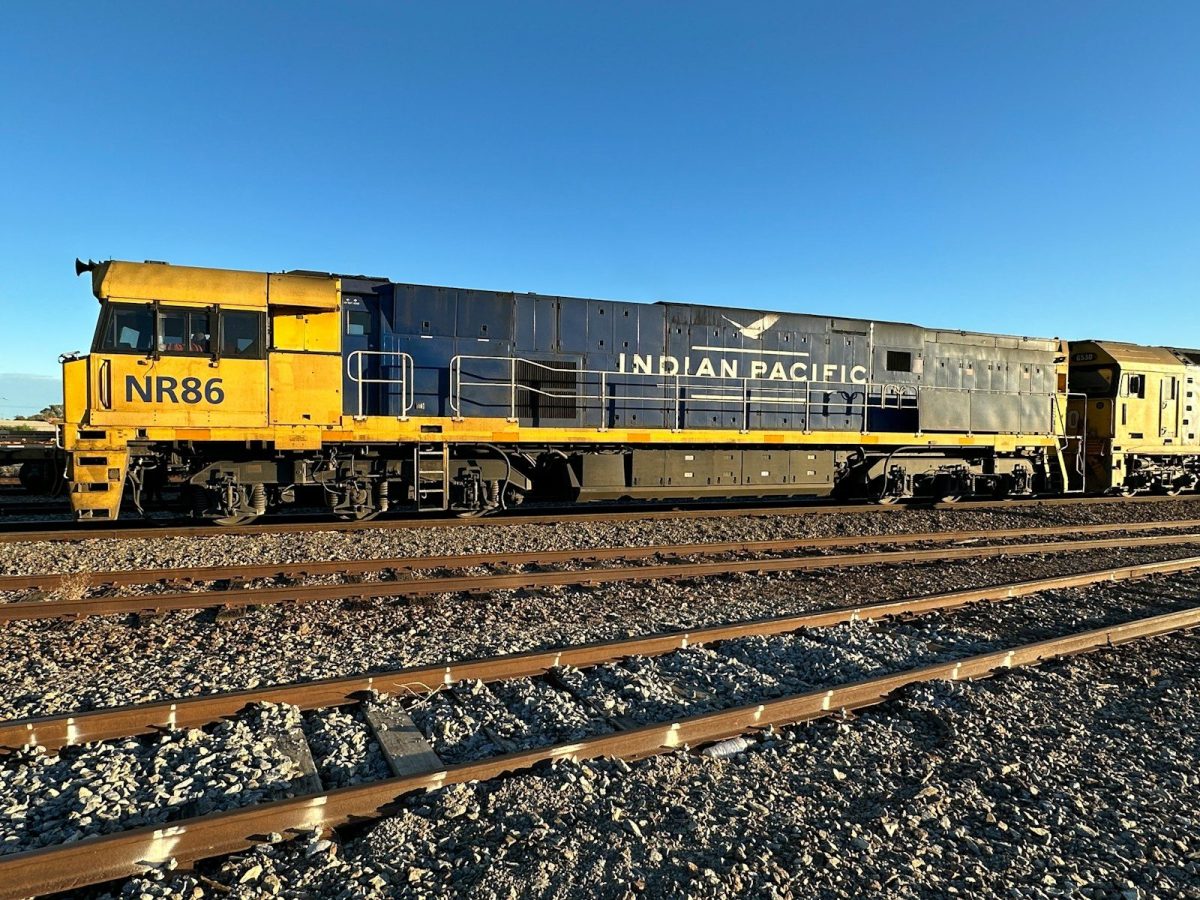 a train traveling down train tracks next to a field