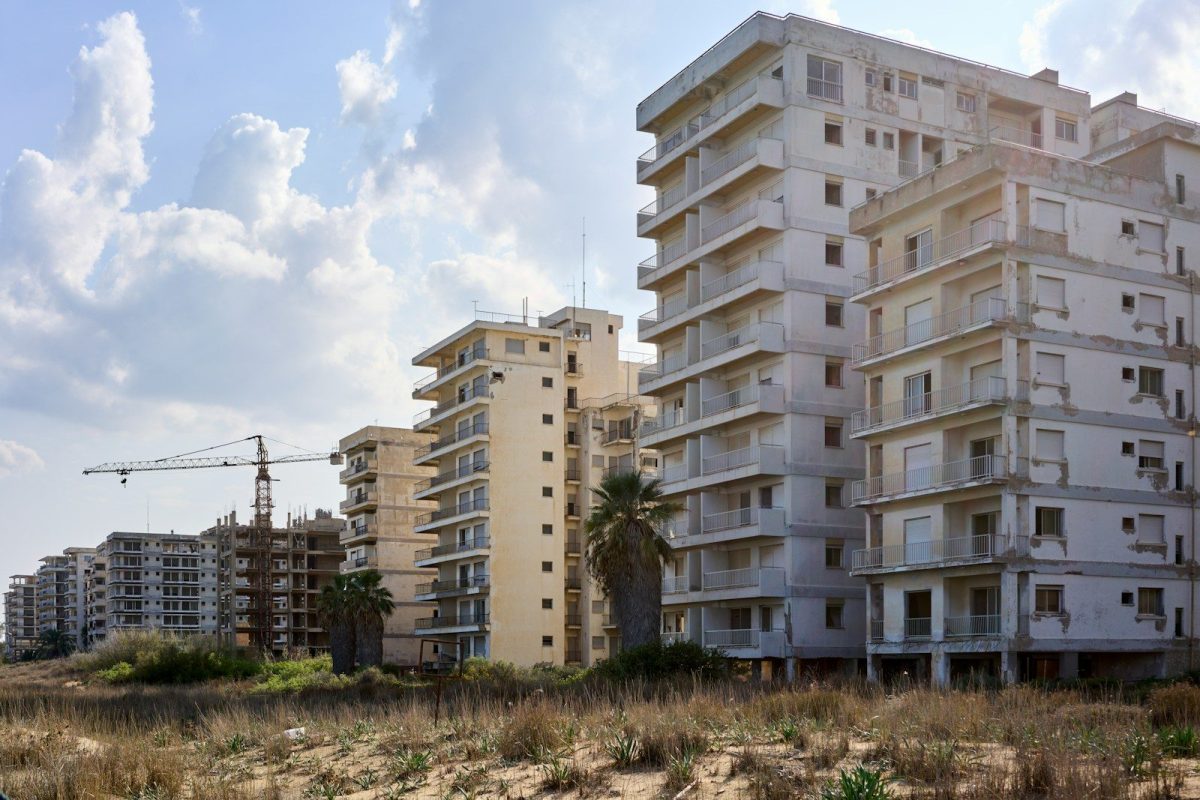 a tall white building sitting on top of a sandy beach